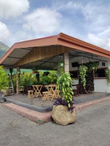 a pavilion with tables and chairs in front of a building at Relax Termalitas Hot Springs in Fortuna