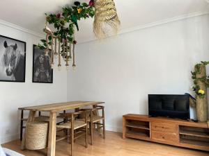 a dining room with a table and a tv at Enjoy Ávila 2 - LA CATEDRAL in Ávila