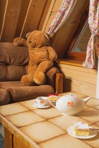 een teddybeer op een stoel naast een tafel bij Miś Pokoje Gościnne in Bukowina Tatrzańska