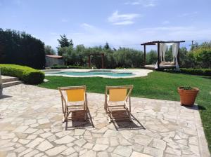 Metókhion PatriotikónにあるVilla Traditional Estate Heated Pool & Garden, 5 bedroomsのプールサイドのパティオ(椅子2脚付)