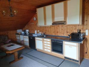 a kitchen with white cabinets and a black appliance at Haus Veronika in Wegscheid