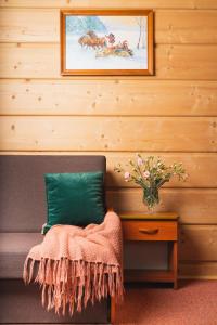 een bank met een kussen en een vaas met bloemen bij Miś Pokoje Gościnne in Bukowina Tatrzańska