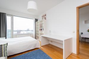 ein weißes Schlafzimmer mit einem Schreibtisch und einem Fenster in der Unterkunft Двухкомнатная квартира в центре города in Tallinn