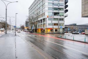 eine Stadtstraße mit einem Gebäude an einem regnerischen Tag in der Unterkunft Двухкомнатная квартира в центре города in Tallinn