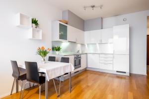 eine Küche mit weißen Schränken und einem Tisch und Stühlen in der Unterkunft Двухкомнатная квартира в центре города in Tallinn
