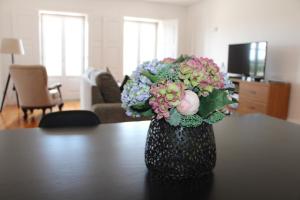 a vase filled with flowers sitting on a table at Alma Da Vila in Ponte de Lima