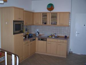 a kitchen with wooden cabinets and a sink at Meerblick Heringsdorf in Heringsdorf