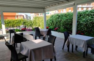 un restaurante con mesas blancas y sillas en un patio en B&B Terrazza Belfiore, en Florencia