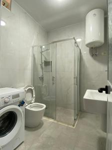 La salle de bains est pourvue d'une douche, de toilettes et d'un lave-linge. dans l'établissement Bellavista Qerret Apartment 1, à Golem