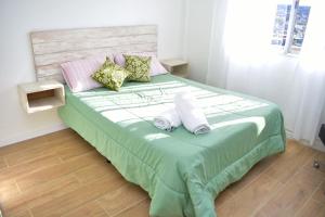- une chambre avec un grand lit et 2 oreillers dans l'établissement la mas linda ventana al mar, à Puerto Madryn