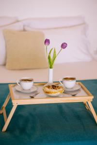 a coffee table with two cups and a vase with flowers at Breathless Sea Studio in Rethymno Town