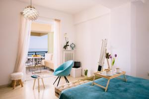 a living room with a bed and a blue chair at Breathless Sea Studio in Rethymno Town
