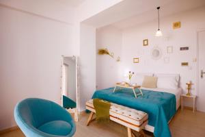 a bedroom with a bed and a blue chair at Breathless Sea Studio in Rethymno Town