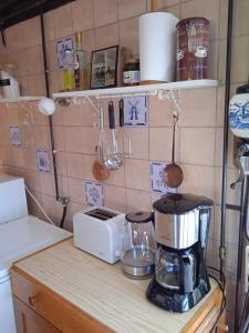 a kitchen counter with a coffee maker and a blender at Vakantiehuis Friedeburg in Warmenhuizen +19 photos