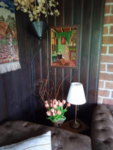 uma lâmpada e um vaso de flores sobre uma mesa em Vakantiehuis Friedeburg em Warmenhuizen
