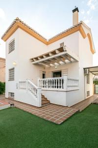 a white house with a green lawn at Casa de la Vega in Cúllar-Vega