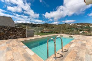 a villa with a swimming pool and a mountain at DejaBlue. Villa rural junto al mar y la montaña in Santa Maria de Guia de Gran Canaria
