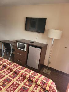 um quarto de hotel com uma cama e uma televisão de ecrã plano em Sterling Inn near IAG Airport em Niagara Falls