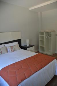 a bedroom with a large bed and a dresser at Casa da Rabeira con terraza barbacoa y aparcamiento in Cambados
