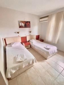 a hotel room with two beds and a window at Acar Park Hotel in Dalyan