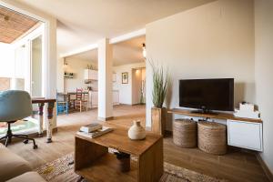 een woonkamer met een televisie en een tafel bij K-COLORS by Nuka Homes in Jávea