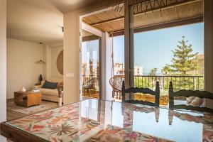 een woonkamer met een glazen tafel voor een raam bij K-COLORS by Nuka Homes in Jávea +25 foto's