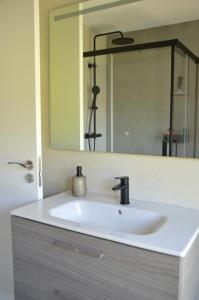 a white sink in a bathroom with a mirror at Casa da Rabeira con terraza barbacoa y aparcamiento in Cambados