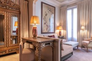a living room with a table and a mirror at Hotel de Montesquieu in Paris