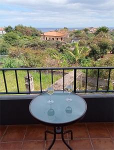 una mesa con 2 copas de vino en el balcón en Scenic Comfort, en Ponta Delgada
