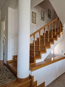 una escalera en una casa con paredes blancas y suelo de madera en The Mirador Boutique Villa with Scenic Sea View, en Porto Rafti