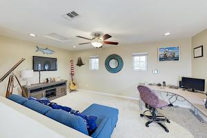 a living room with a blue couch and a ceiling fan at Westwood House in Oceanside