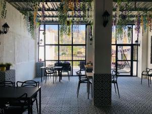 a restaurant with tables and chairs in a room with windows at Zaman Ya Zaman Boutique Hotel in Amman