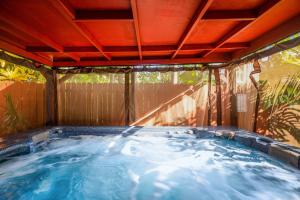 a hot tub in a backyard with a wooden roof at Tropic Dream in Key West