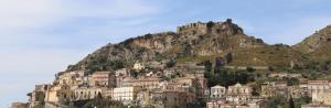 une ville sur une colline avec une montagne dans l'établissement DIMORE MORELLI, à Amantea