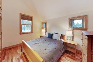 1 dormitorio con 1 cama grande y 2 ventanas en Cottage Charms en South Lake Tahoe