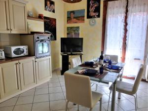 cocina con mesa con sillas y TV en Casa di Giada appartamento luminoso a due passi dalla tramvia per Firenze, en Scandicci