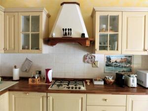 uma cozinha com armários brancos e um forno com placa de fogão em Casa di Giada appartamento luminoso a due passi dalla tramvia per Firenze em Scandicci