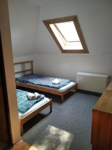 2 camas en una habitación pequeña con ventana en Penzion U Jezu Dobronice, en Dobronice