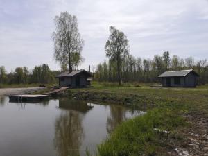 two small buildings next to a body of water at Mõiskla saun ja puhkemaja in Haapsalu