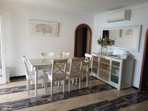 una sala da pranzo con tavolo, sedie e uno specchio di Voramar debaix a Alcudia