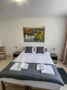 a bedroom with a large bed with two towels on it at Happy Hill Rooms in Banja Luka +21 photos