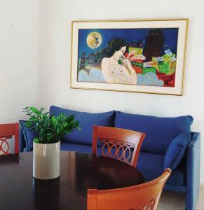 a blue couch with a table and a picture on the wall at Alykes Family Resort in Lefkímmi