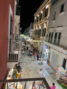 a group of people walking down a street at night at Al Civico 3 CENTRO in Polignano a Mare