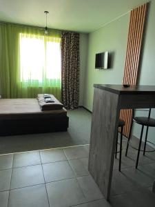 a bedroom with a bed and a table and a window at Belvederska apartment 4 in Ivano-Frankivsʼk