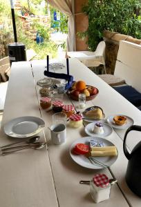 una mesa blanca con platos de comida. en Guest Room B&B Agro-turismo Quinta da Fonte, en Figueiró dos Vinhos