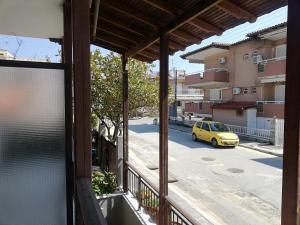 a view from a balcony of a street with a yellow car at House Anna Sarti in Sarti