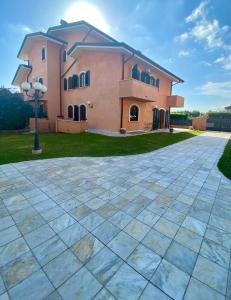 a large pink house with a stone driveway at Villa Silvana in Querceta