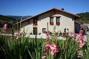 a house with flowers in front of it at Agroturismo La Casa Vieja in Maturana