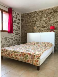 een slaapkamer met een wit bed en een sprei met bloemen bij O’gîtes des colombes in Colombiers +15 foto's