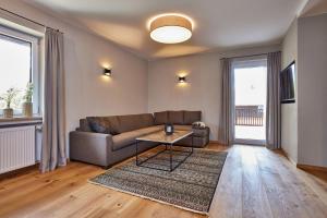 ein Wohnzimmer mit einem Sofa und einem Tisch in der Unterkunft Ferienwohnung Reintal mit Sauna für 2-6 Personen 110 qm in Garmisch-Partenkirchen